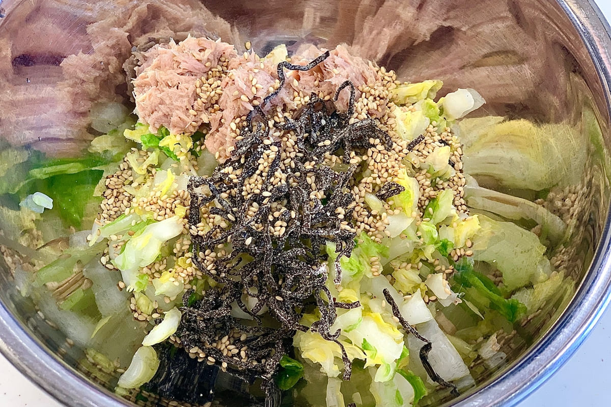 水気を絞った白菜、油を切ったツナ、塩昆布、白ごまを合わせている様子