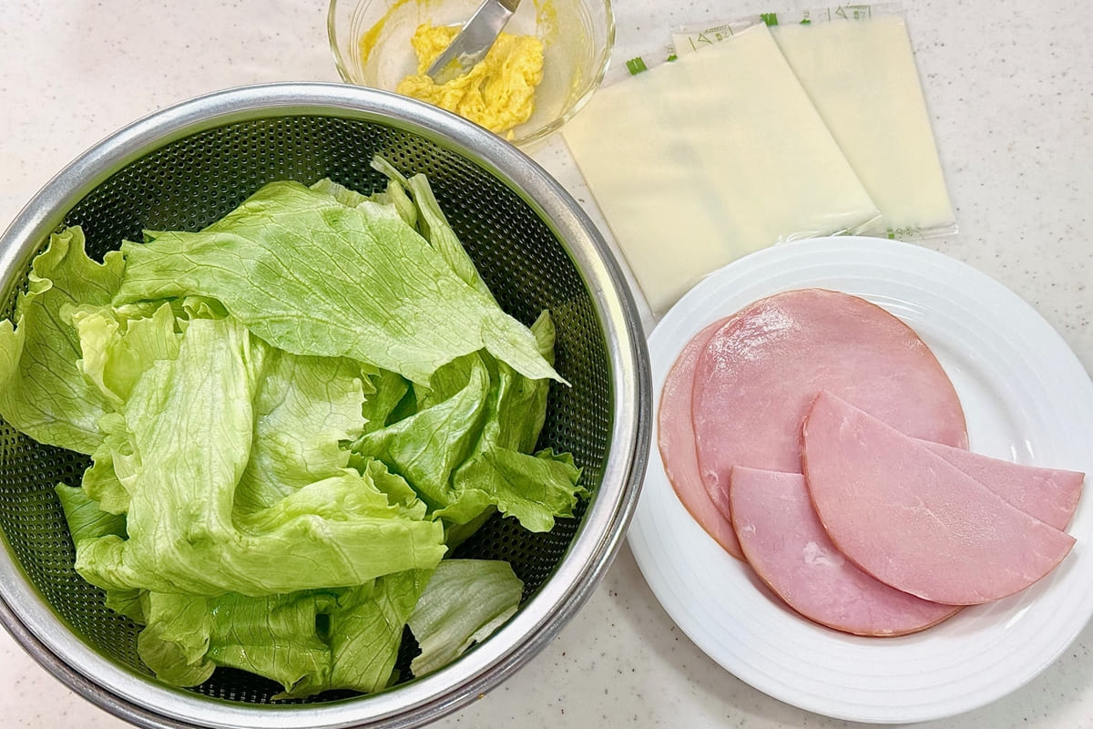 レタスを大きめにちぎり、ハム4枚を半分にカットしたところ